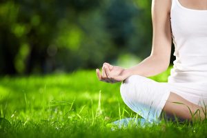 Yoga, lotus pose, outdoors on grassy field
