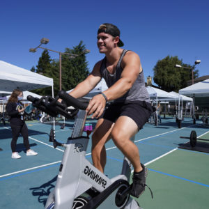 A JCC Los Gatos member on an outdoor stationary bike.