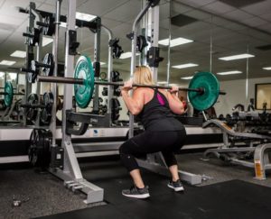 Member performing a squat with weights.